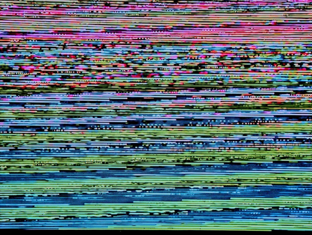Glitched TV screen showing colorful pixel distortion and signal failure — TV screen replacement cost guide 2026