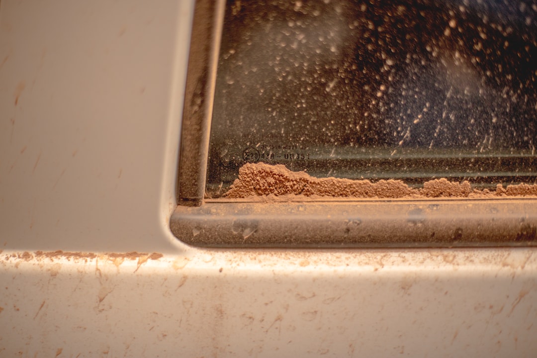 Fine desert sand and dust caked around a ventilation slot — showing how dust storms in Abu Dhabi block airflow and cause TV overheating and screen flickering.