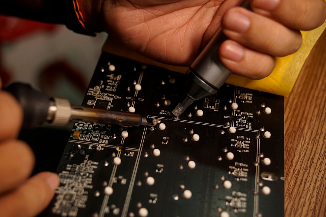 Close-up of technician soldering a TV circuit board – common TV problems diagnosis and repair